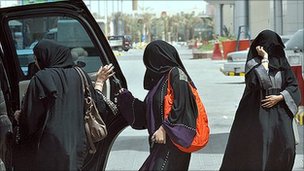 Saudi women get in the back seat of a car