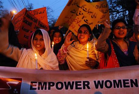 Pakistani human rights activists hold candles as they shout slogans during a rally in Lahore on March 7, 2011 on the eve of International Women's Day. 