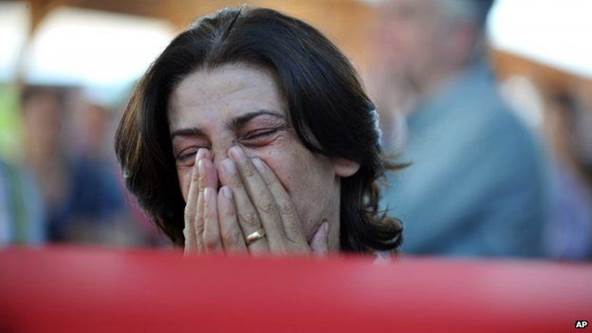 A woman mourns over the coffin of a bombing victim in Gaziantep, Turkey, Tuesday, July 21, 2015